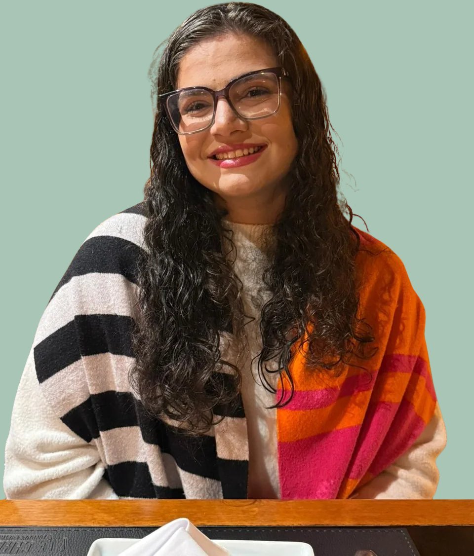Foto de Ana Tereza Netto Viana, psicóloga clínica, sorrindo, de óculos e cabelos cacheados